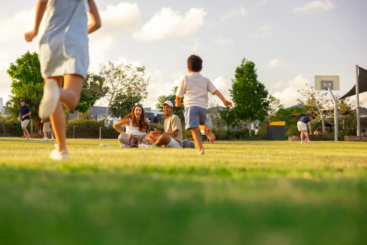 A child running across a lawn towards a family picnic