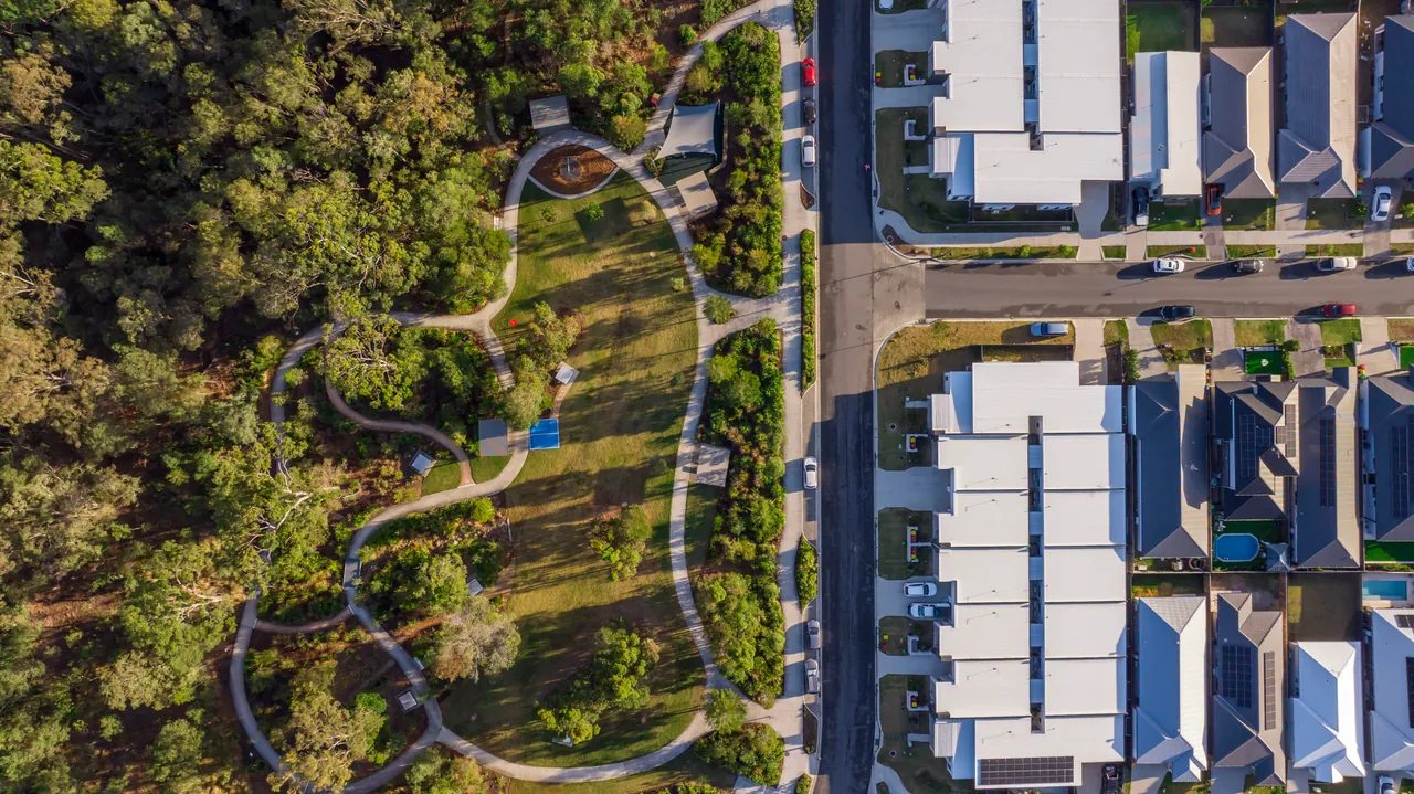 An aerial view of new streets and homes beside a bushland reserve