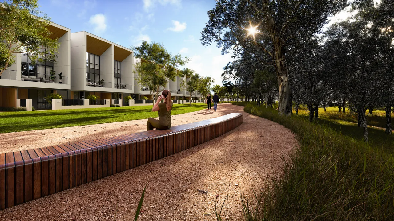 A woman sitting on a curved timber bench beside a gravel path, with new terrace homes and tall gum trees
