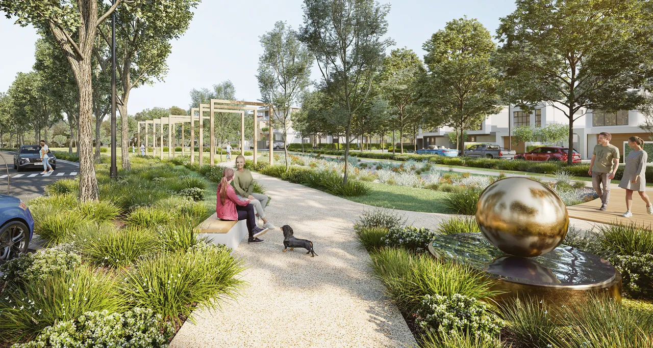 A polished bronze egg sculpture on a water feature beside a garden path, with a couple walking past new homes